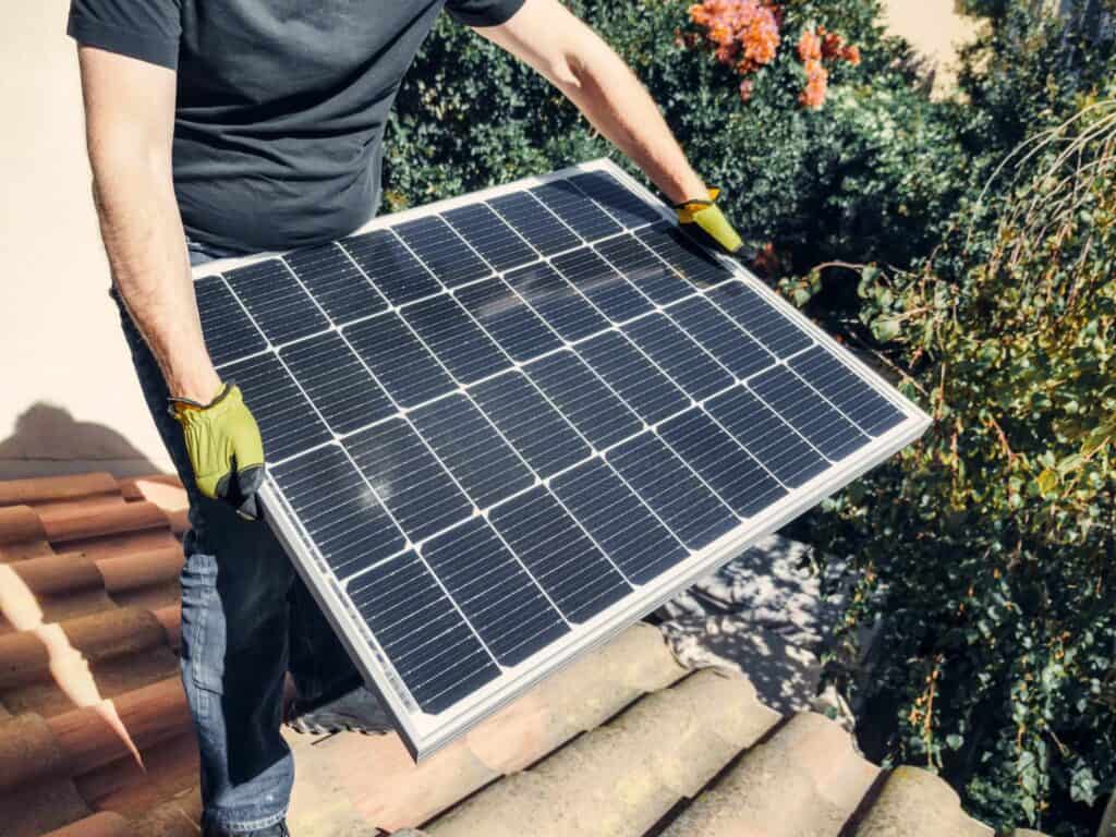 Holding a Solar Panel while Standing on the Roof