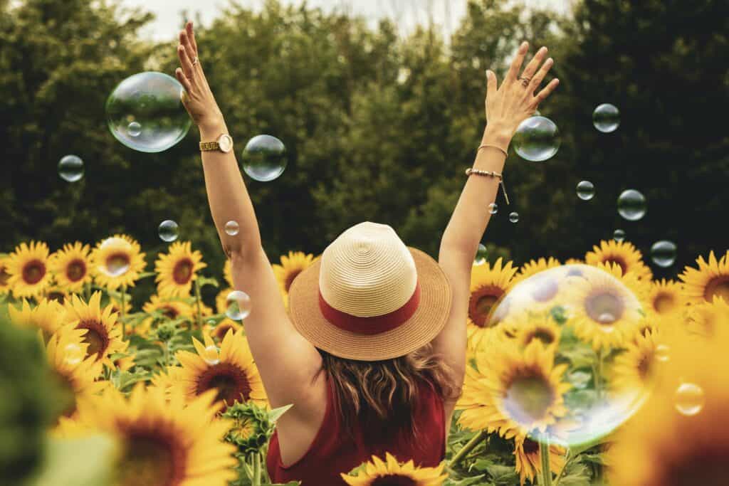 Woman Surrounded By Sunflowers in a hat