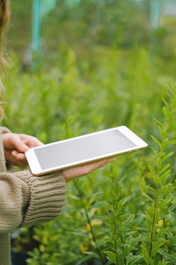 Woman using tablet for collecting information about plants