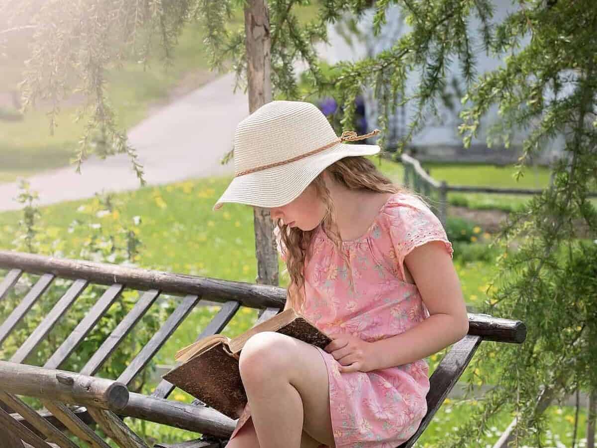 Girl Wearing Hat Sitting Reading a book